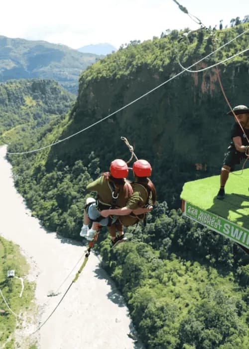 Couple swing on a cliff