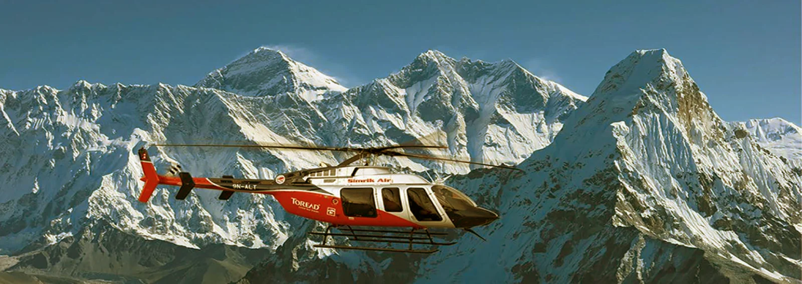Scenic view of mountains with a helicopter, representing helicopter tours